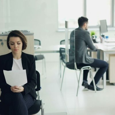Woman sitting in office holding papers